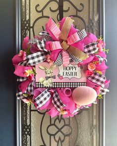 a pink and black wreath on the front door of a house that says happy easter