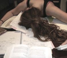 a woman laying on top of an open book