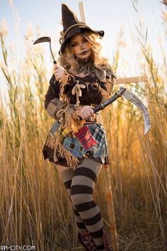 a woman dressed as a scarecrow holding a pitchfork