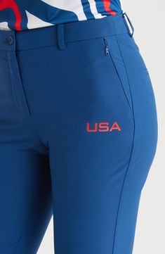 the back view of a woman's leg wearing blue pants with usa embroidered on it