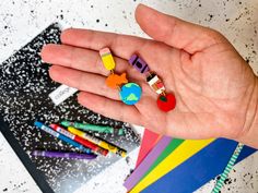 a person's hand holding several different colored crayons in their left palm