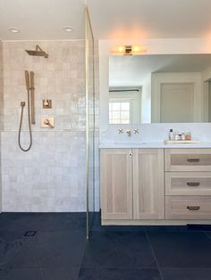 a bathroom with a sink, mirror and shower head in it's center area