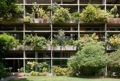 an apartment building with plants growing on the balconies