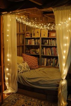 a bed with white curtains and lights hanging from it's sides in a room