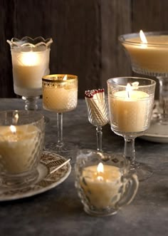 a table topped with glasses filled with candles