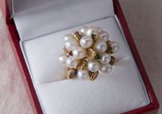 "This over the top, eye catching cocktail ring has to be worn to be appreciated. The ring features a cluster of 17 lustrous white pearls, accented by yellow gold nuggets and genuine gemstones arranged through out the design. The setting sits high on top of the finger but the band is flat and comfortable to wear. This retro era ring truly embodies the \"big and bold\" look of that time period and will definitely be a conversation starter on your hand! GEMSTONES: Genuine Sapphires: 2 @ 1.75mm, Gen Luxury White Multi-stone Cluster Ring, White Pearl Ring With 17 Jewels For Formal Occasions, White Cluster Ring For Formal Occasions, White Cluster Ring With 17 Jewels, Formal White Cluster Ring, Formal Multi-stone Pearl Ring In Fine Jewelry Style, Elegant Formal Multi-stone Pearl Ring, Elegant White Multi-stone Rings, Elegant Cluster Pearl Ring For Formal Occasions