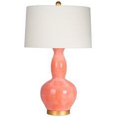 an orange lamp with a white shade on it and a gold frame around the base