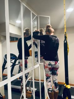 two women in black shirts and white pants on a lift