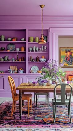 a dining room with purple walls and furniture