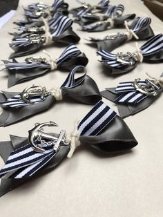 several black and white bows tied together with silver metal clasps on top of a table