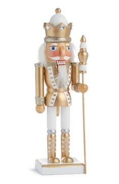 a gold and white nutcracker figurine with a golden crown on top