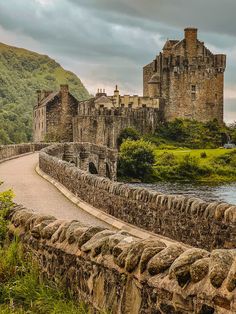 an old castle sits next to a river