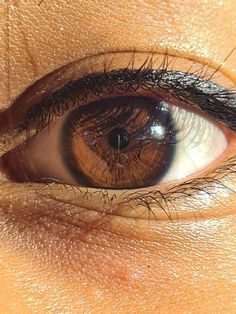 an extreme close up shot of someone's eye with brown and black irises