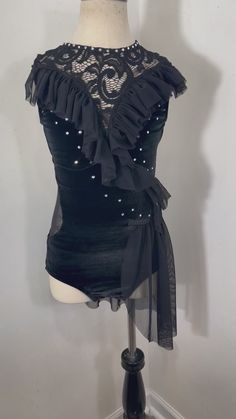 a mannequin wearing a black top with pearls on it