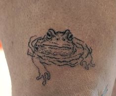 a tattoo on the back of a man's leg with a frog drawn on it