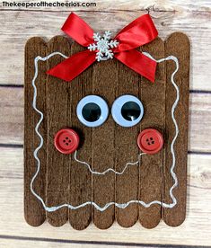 a wooden plaque with buttons and eyes on it