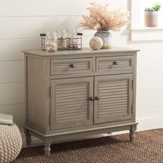 a gray cabinet with two doors and drawers in a living room next to a rug