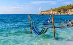 a hammock hanging in the water on a beach