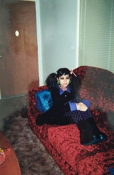 a woman sitting on top of a red couch