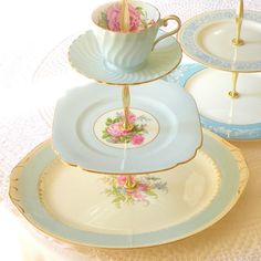 three plates stacked on top of each other with cups and saucers in the middle