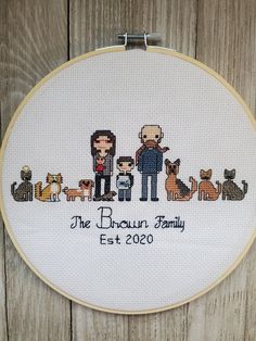 the cross stitch family is featured in this embroidery pattern on a wooden background with text that reads, the brown family est 2050