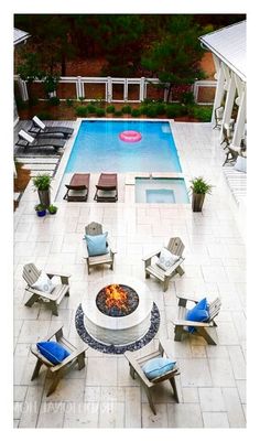 an aerial view of a fire pit surrounded by lawn chairs and loungers next to a swimming pool