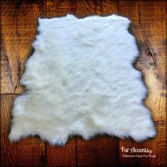 a white sheepskin rug on top of a wooden floor