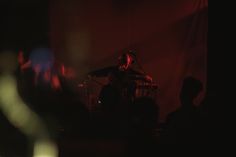 a man standing on top of a stage next to a microphone in front of a crowd