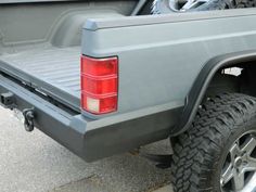 the back end of a gray truck parked in a parking lot