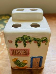 a white ceramic container sitting on top of a wooden table