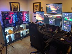 a room filled with computer monitors and gaming equipment