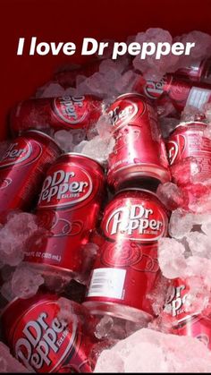 a pile of red soda cans sitting on top of ice covered in sugar and water