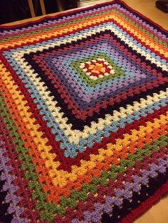 a crocheted blanket is laying on the floor