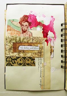 an open notebook with altered images and writing on the pages, along with a pink flower