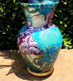 a colorful vase sitting on top of a stone slab