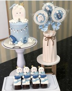 baby shower items displayed on small trays in front of cake and cupcakes