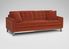 an orange couch with two pillows on it