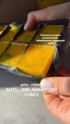 a person is holding onto some kind of yellow substance in their hand, with the caption'anti - imflamatory cubes '