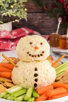 two snowmen made out of rice and carrots on a plate with crackers