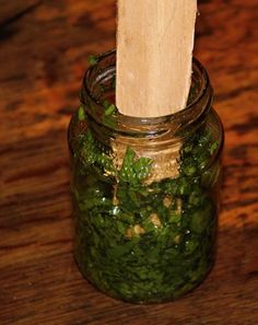 a wooden stick sticking out of a jar filled with green stuff