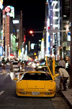 a yellow sports car parked on the side of a street