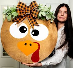 a woman holding up a wooden turkey head