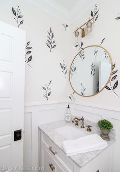 a bathroom sink with a mirror above it and wallpaper on the walls behind it