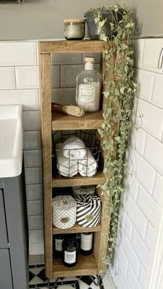 the bathroom is decorated in black and white with lots of greenery on the shelves