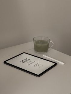 a tablet, pen and glass on a table