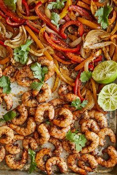 a tray filled with grilled shrimp, peppers and cilantro