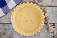 a pie crust with the letter f on it and paintbrushes next to it