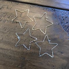 three star shaped cookie cutters sitting on top of a wooden table