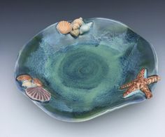 a bowl with shells and starfishs on it