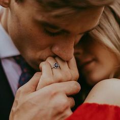 a man and woman are holding each other close to one another with their hands together